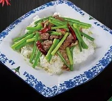 Stir-fried garlic shoots with pork over rice