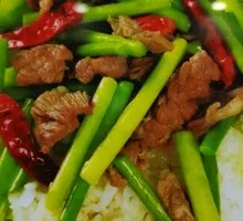 Stir-fried garlic shoots with pork over rice